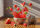 Fresh watermelon chunks splashing from floral bowl