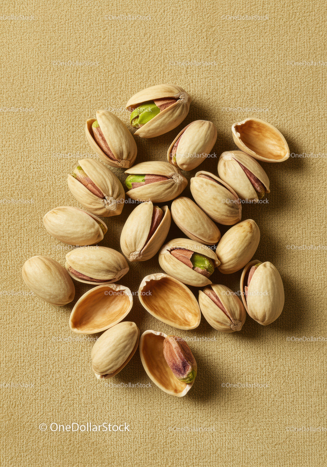 Close up of scattered pistachios on textured surface