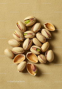 Close up of scattered pistachios on textured surface