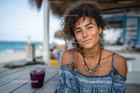 Young Woman with Curly Hair Smiling at Beachside Cafe