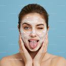 Woman with Clear Skin Applying Facial Cleansing Against Blue Background