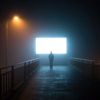 Silhouetted Man Standing Before Bright Screen at Night