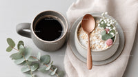 Ceramic Coffee Mug and Oatmeal Bowl with Rose Berries on Neutral Table