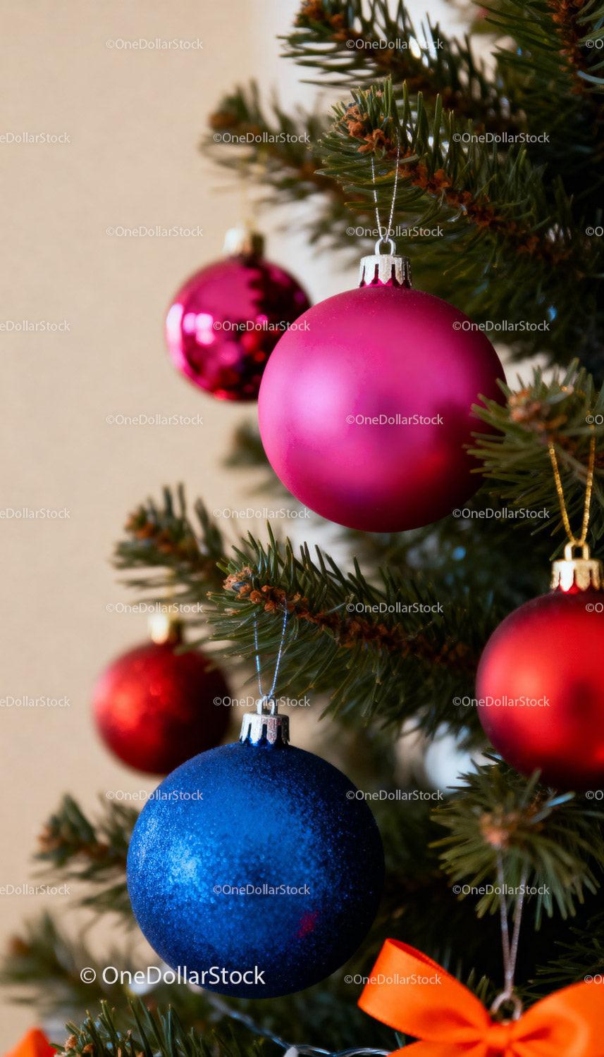 Colorful Christmas ornaments hanging on green tree