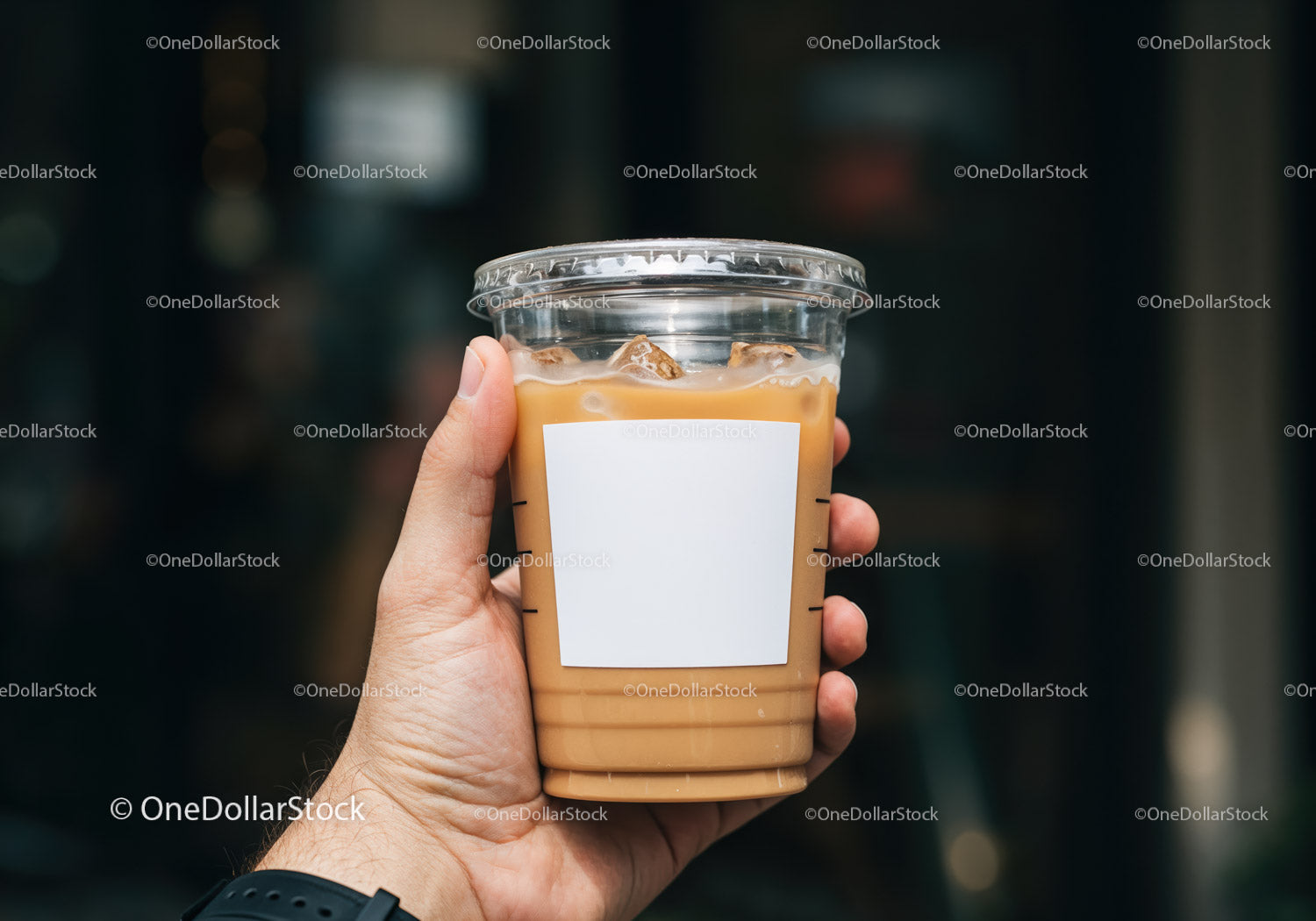 Hand Holding Plastic Cup of Iced Coffee with Milk