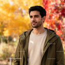 Thoughtful young man standing outdoors in autumn park