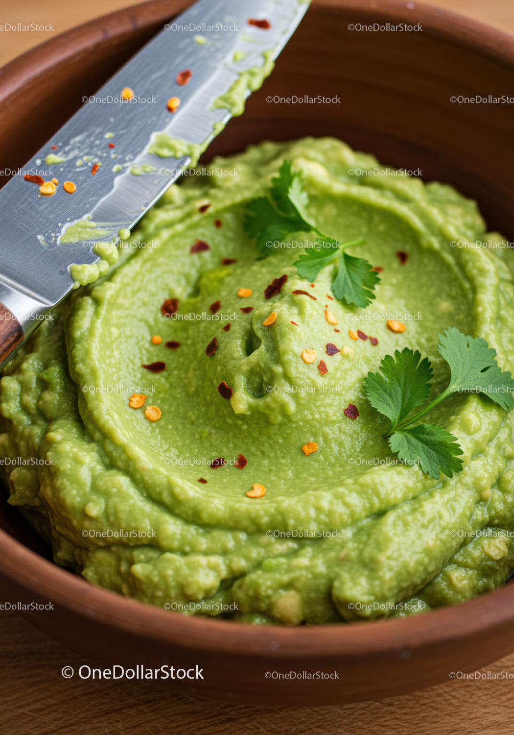 Creamy guacamole dip garnished with cilantro and chili flakes