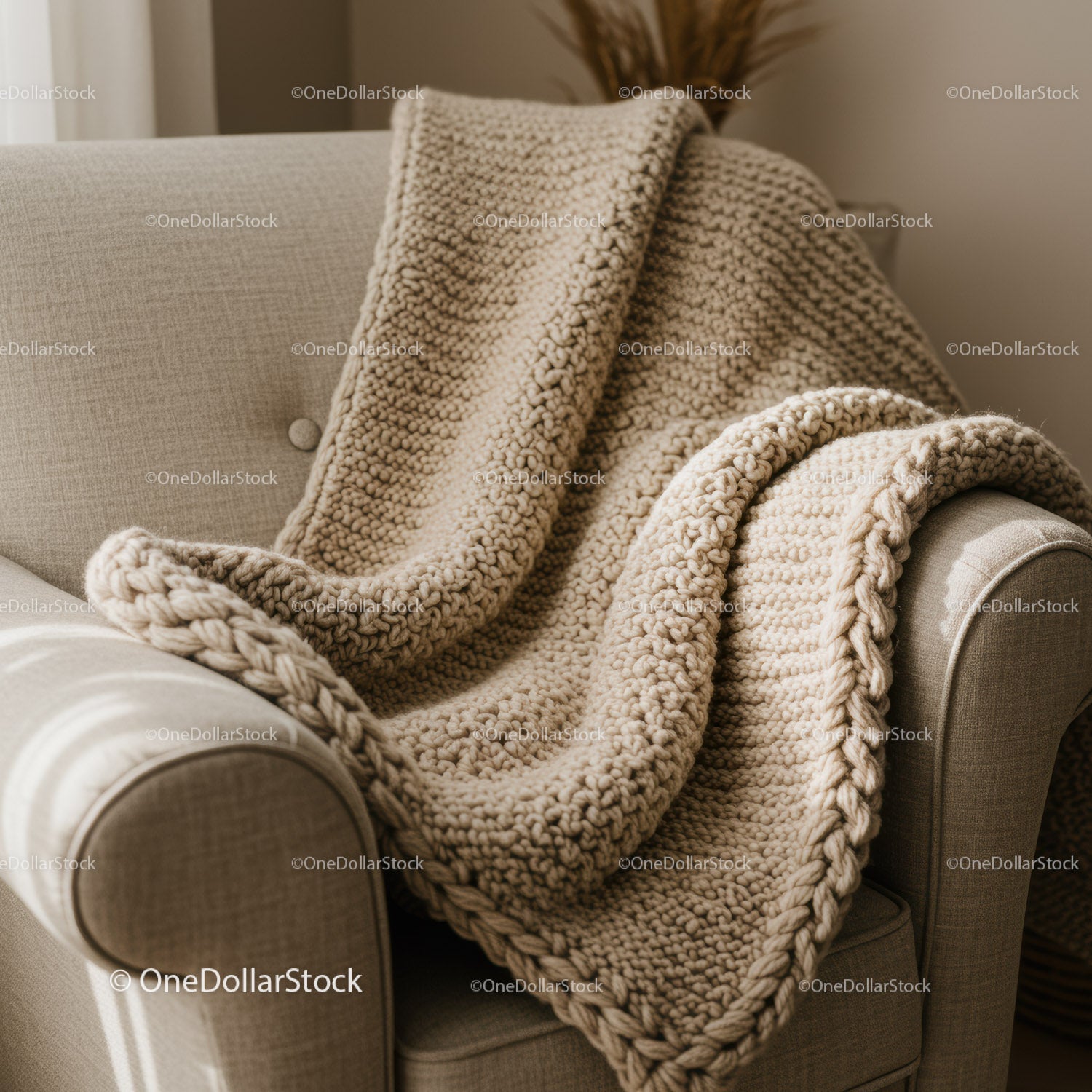 Cozy beige knitted blanket on armchair in warm interior