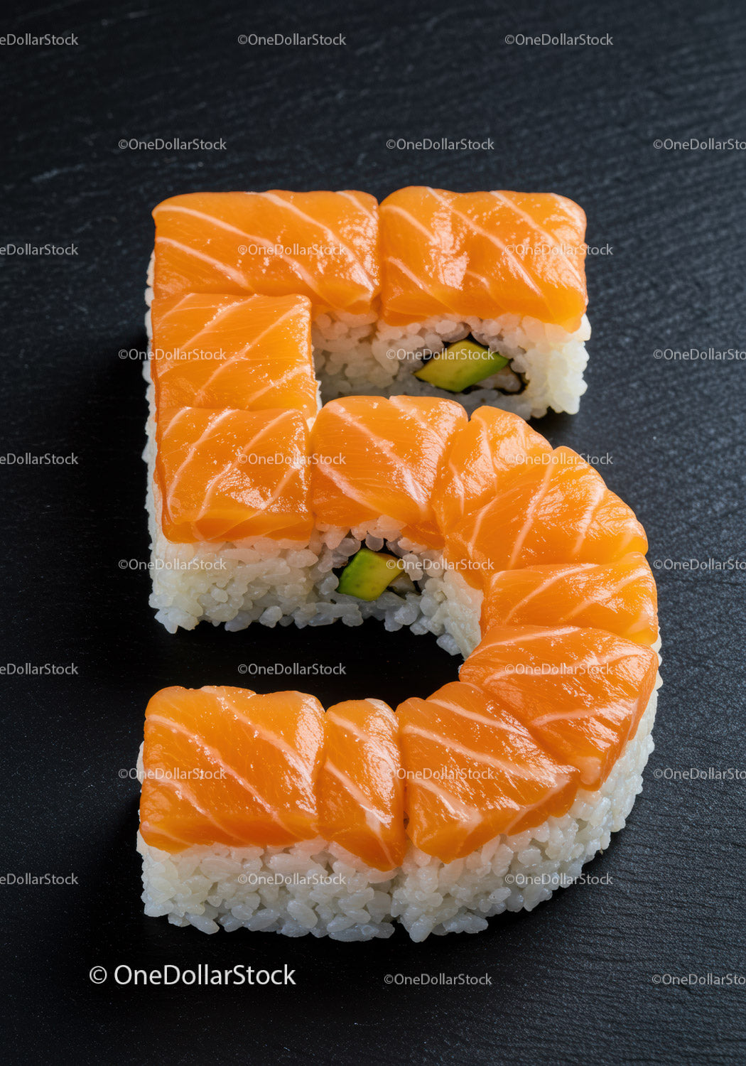 Kawałki sushi ułożone w kształt cyfry pięć na czarnym łupku