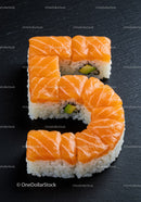 Sushi pieces arranged in number five shape on black slate