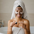 Young Woman with Facial Mask and Towel Wrap Relaxing at Home