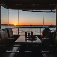 Sunset View from Ferry Interior Over Ocean Horizon with Watercraft