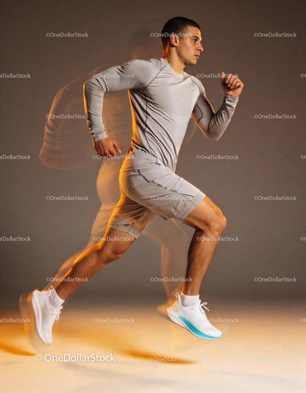 Young man running indoors in modern athletic wear