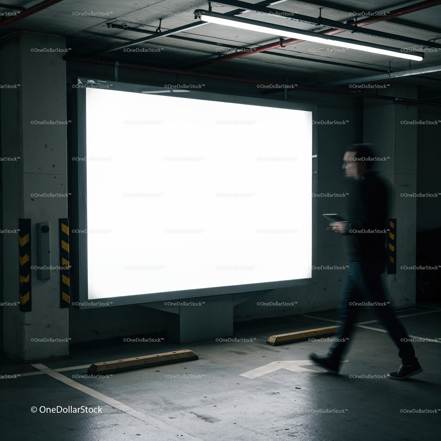 Man walking past illuminated blank billboard in parking garage