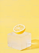 Fresh lemon half resting on clear ice cube