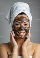 Young Woman with Facial Mask Applying Skincare Treatment