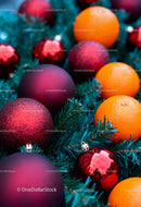 Christmas ornaments and fresh oranges on pine branches