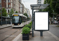 Modern tram arriving at urban city stop with blank ad board