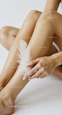 Elegant Female Legs with White Feather and Soft Skin