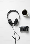 Black Headphones and Digital Camera with Coffee Mug on White Surface
