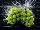 Fresh Green Grapes Splashing into Water with Bubbles