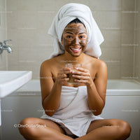 Young Woman Enjoying Facial Mask and Glass of Chocolate in Bathroom