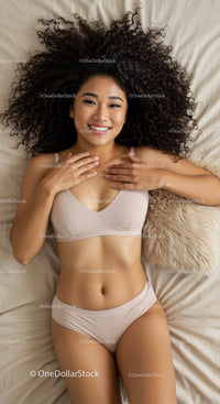 Smiling woman relaxing on bed with natural curly hair