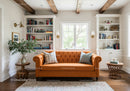 Cozy living room with orange tufted sofa and natural light