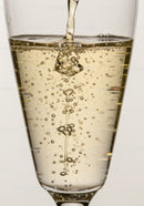 Effervescent bubbles rising in a clear champagne glass