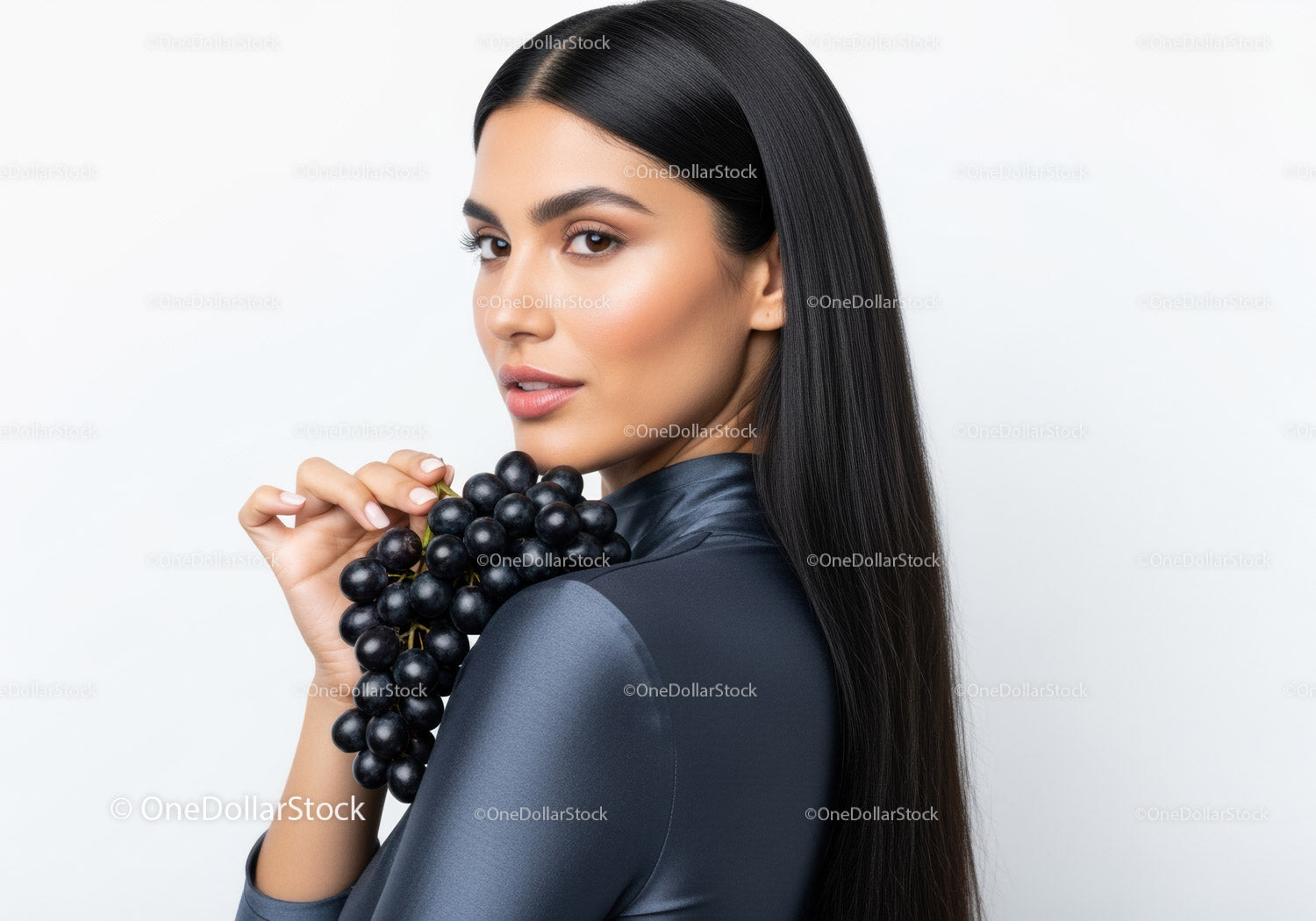 Elegant Woman with Black Hair Holding Bunch of Dark Grapes