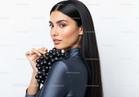 Elegant Woman with Black Hair Holding Bunch of Dark Grapes
