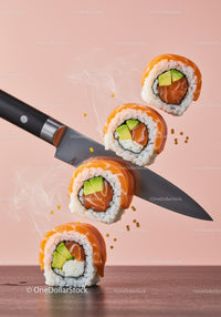 Fresh sushi rolls balanced on sharp kitchen knife blade