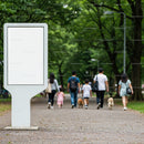Families walking dogs in lush green park pathway