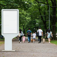 Families walking dogs in lush green park pathway