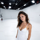 Young Woman in White Dress Posing in Modern Photography Studio