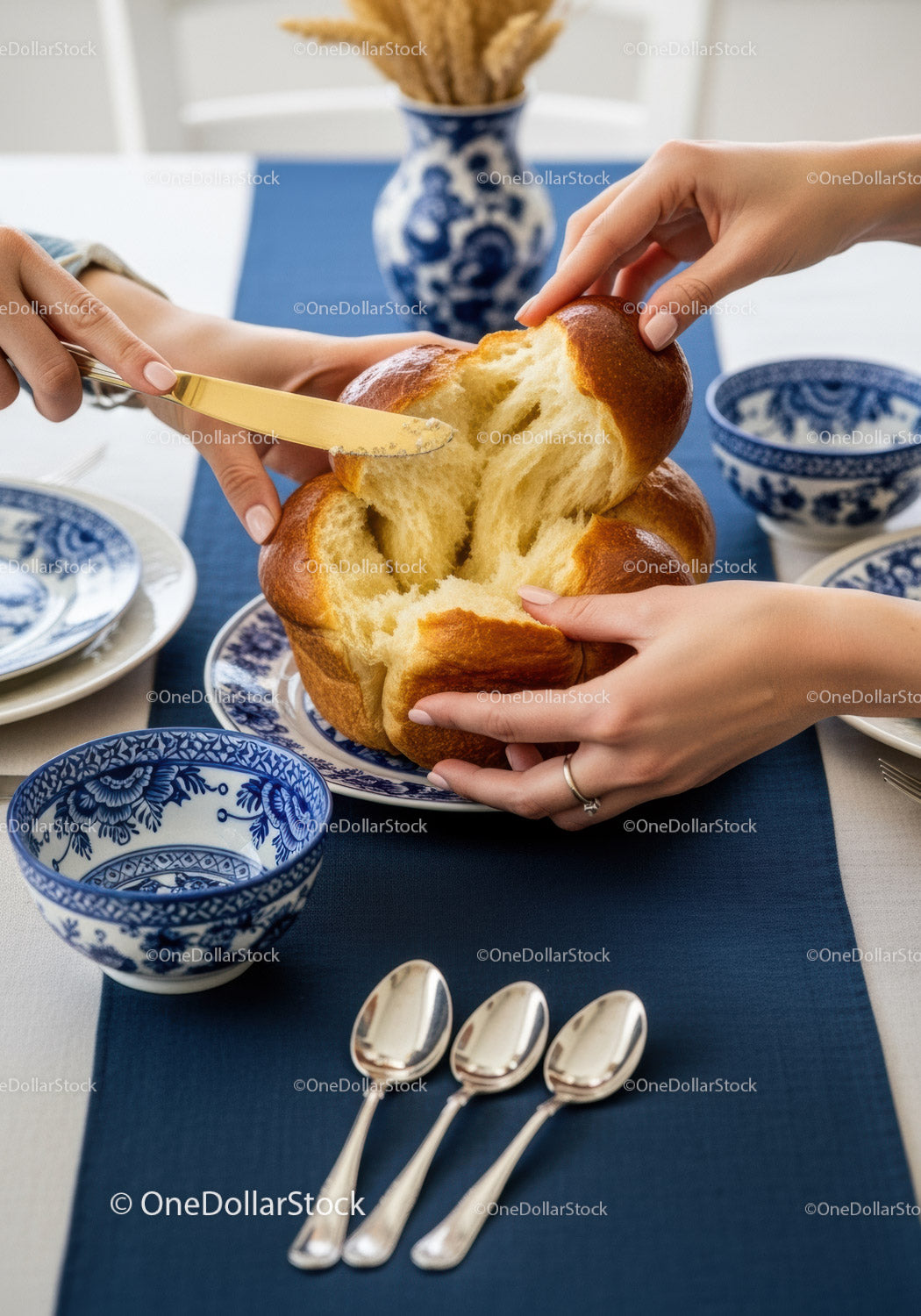 Fresh Artisan Bread Being Shared on Elegant Blue and White Dining Table