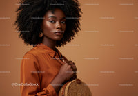 Elegant Woman with Curly Hair in Amber Blouse on Soft Brown Background