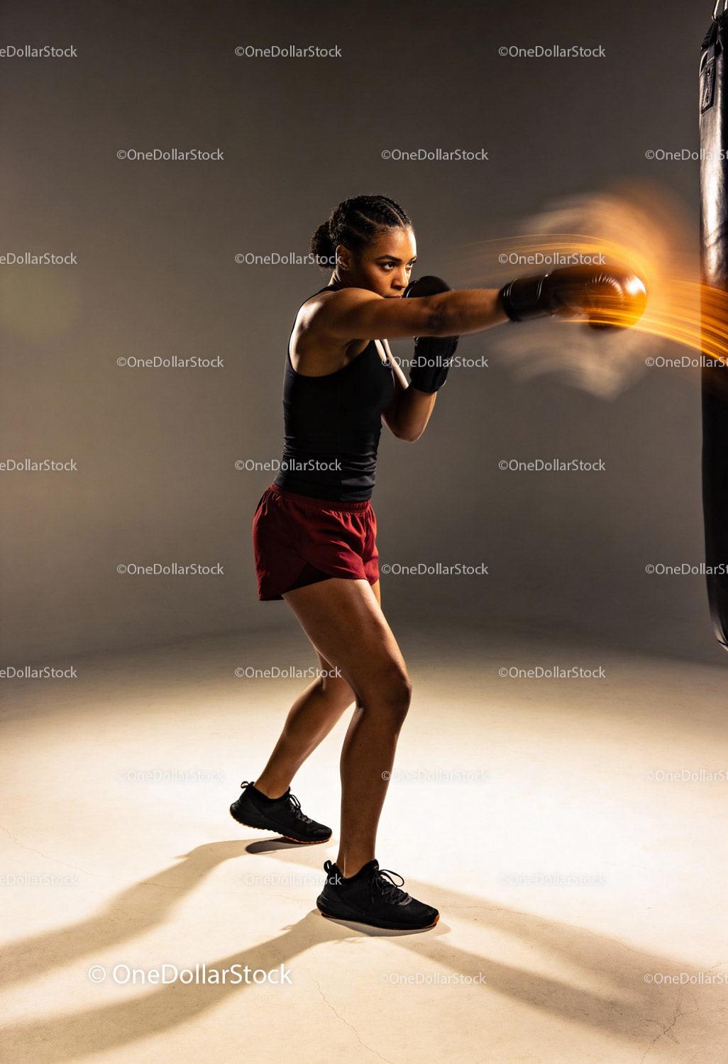 Focused woman delivering powerful punch during boxing training