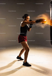Focused woman delivering powerful punch during boxing training