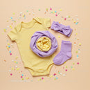 Yellow Baby Bodysuit with Purple Accessories and Confetti