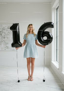 Teenage girl holding balloons celebrating sixteenth birthday