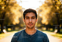 Young man standing in autumn park with calm look