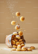Mini pancakes falling from an open snack bag on beige background