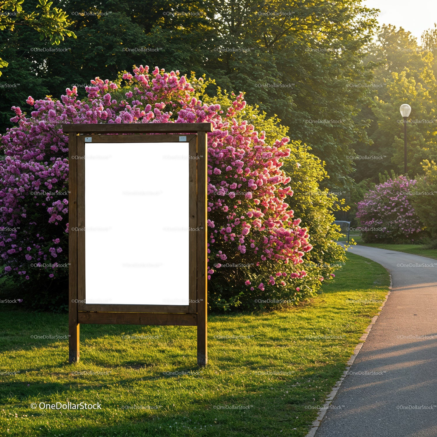 Blank wooden park sign surrounded by blooming flowers