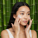 Young Woman Applying Sunscreen in Natural Setting