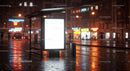 Illuminated Bus Stop Shelter with Wet Street Reflections at Night