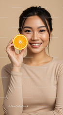 Smiling Woman with Orange Slice in a Bright Neutral Background