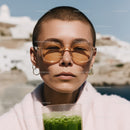 Young Woman with Short Buzz Cut Wearing Sunglasses Holding Green Juice