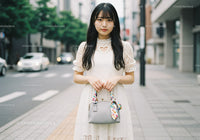 Elegant Young Woman in White Lace Dress Holding Handbag on City Street