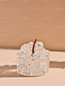Transparent Jelly Dessert with Cherry Stem on Beige Surface
